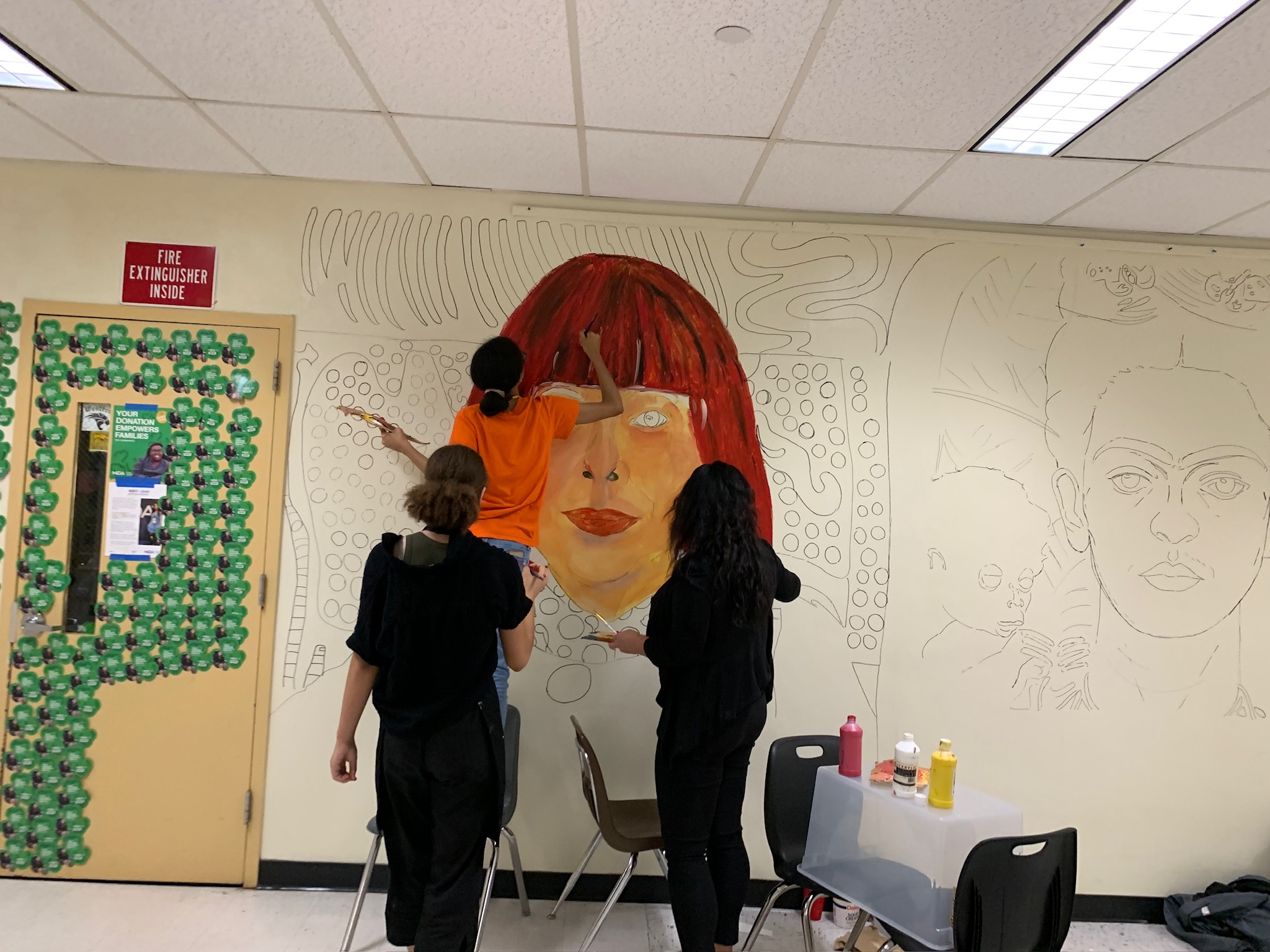 Western High School art students painting the Wall of Artists mural