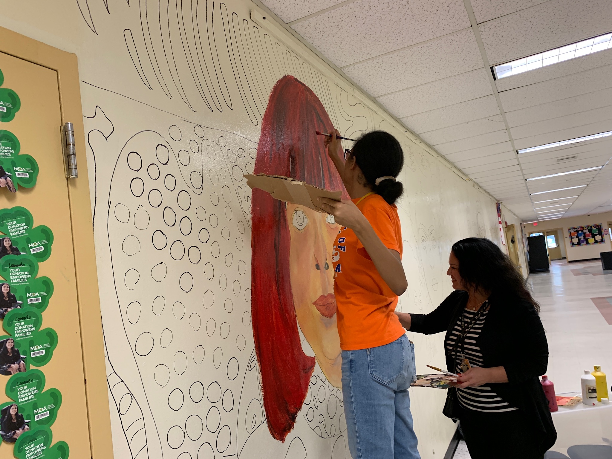 Western High School art students painting the Wall of Artists mural