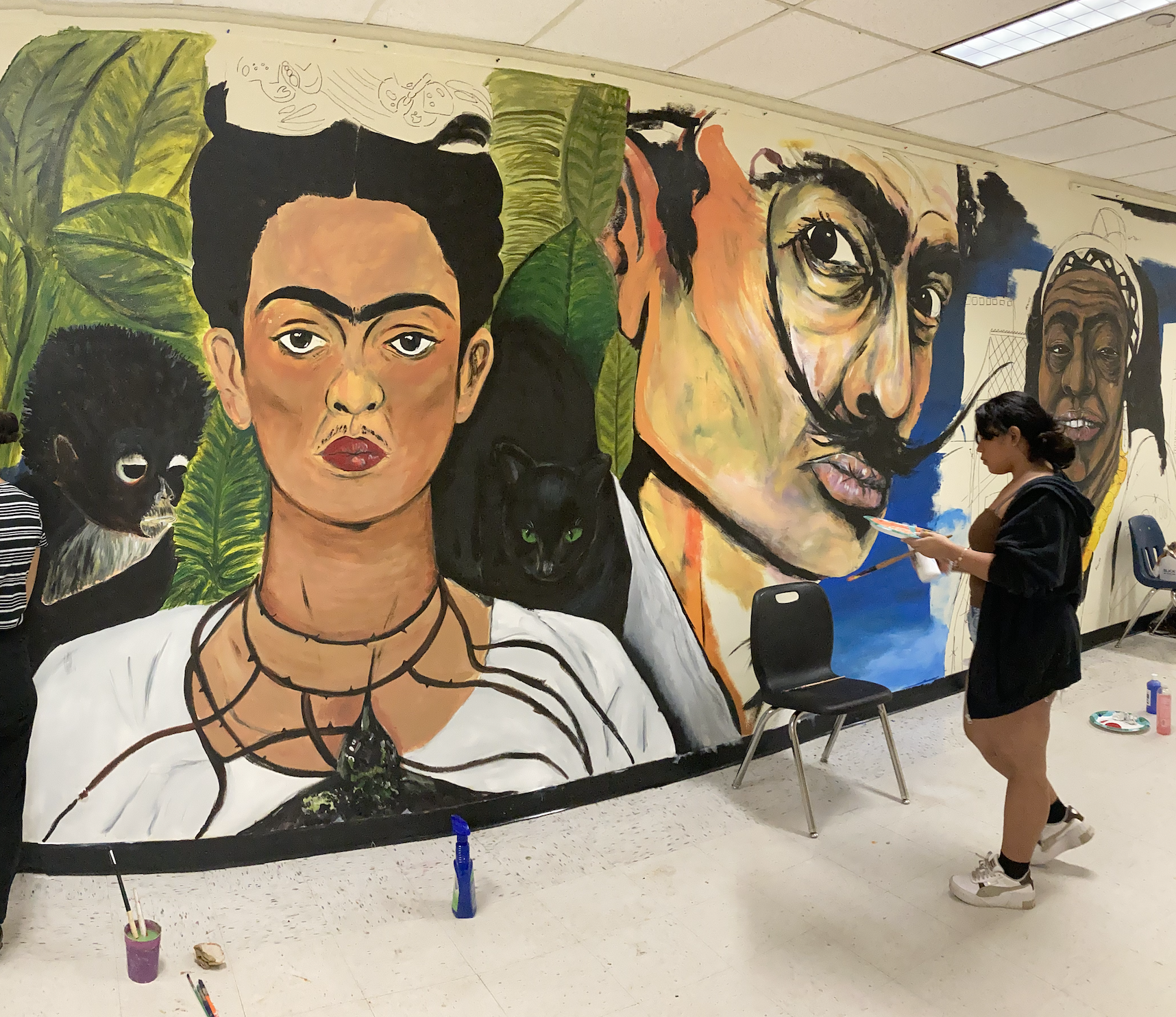 Western High School art students painting the Wall of Artists mural