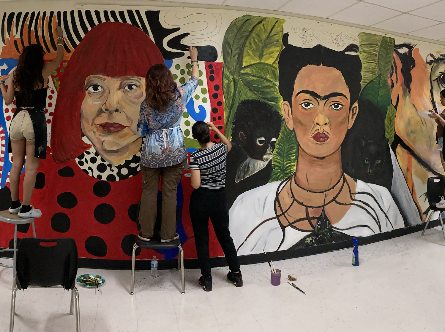 Western High School art students painting the Wall of Artists mural